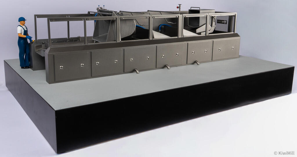 Side view of the cooking line model at eye level, worker figure beside the loading infeed and open guard frames
